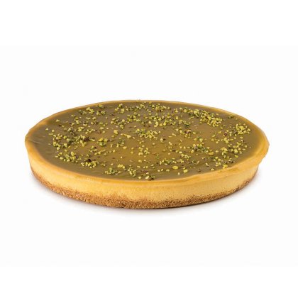 Okrągła tarta z gładkim karmelowym lukrem, kruchym spodem i posypką z posiekanych pistacji.